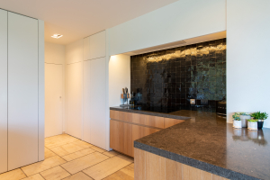 Licht en warm keukenontwerp met natuurlijke materialen en maatkasten.