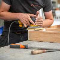 Vakman van Mivan aan het werk aan een houten maatkast in het atelier in Houthulst.